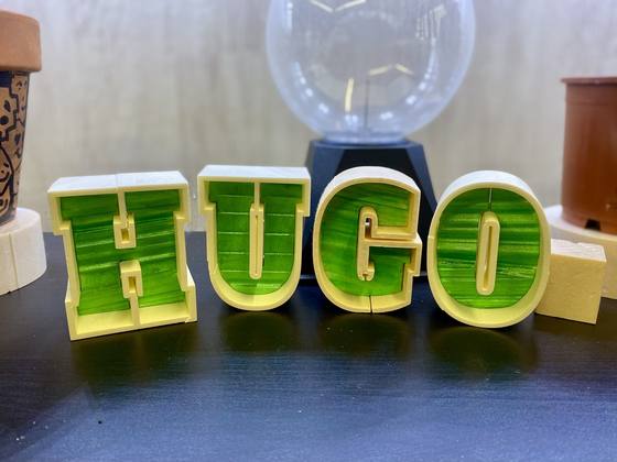 Letras HUGO en volumen con fondo de color