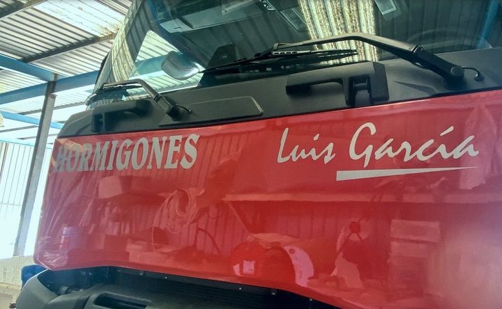 Frontal del camión rojo con Hormigones y Luis García en vinilo plateado